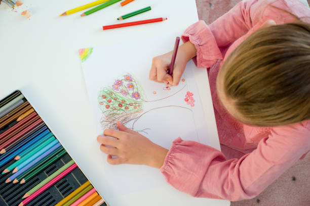 istock High Angle View Of Young Girl Drawing Tree On White Paper 868057098