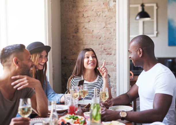 istock Four happy friends having wine and dinner together 868071854