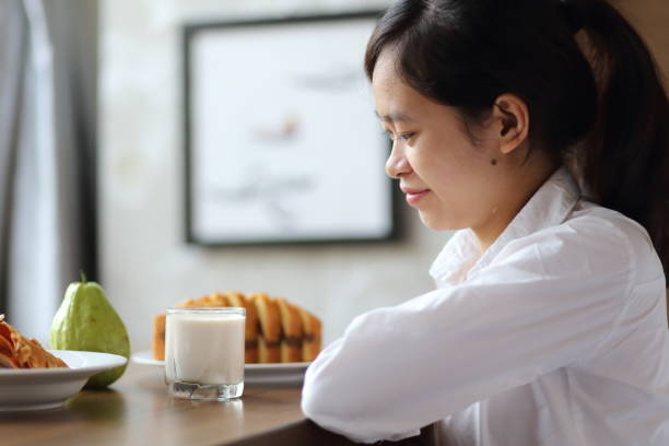 istock Young woman eating breakfast with milk 868083598