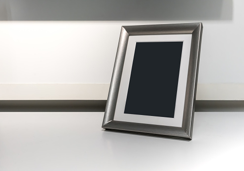 Black space on vertical silver aluminum frame on white desk