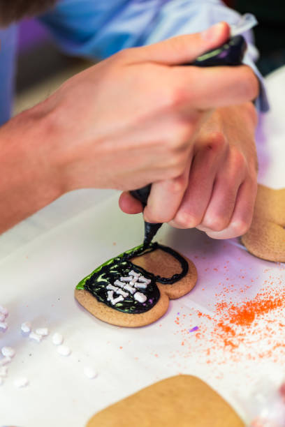 istock Learning how to make and decorate Halloween cookie decorating class. 868098520