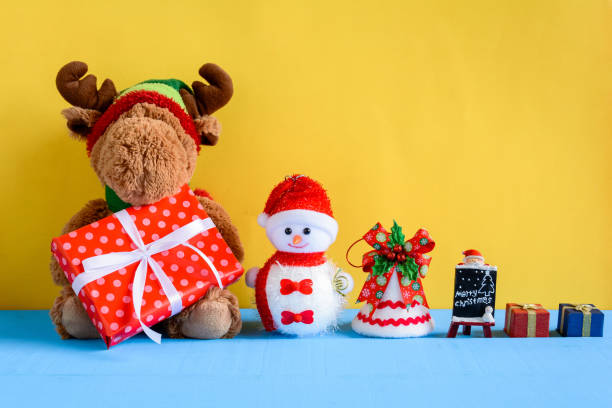 istock doll and gift boxes on wood desk yellow wall background 868098610