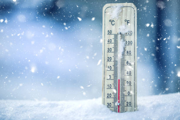 Thermometer on snow shows low temperatures - zero. Low temperatures in degrees Celsius and fahrenheit. Cold winter weather - zero celsius thirty two farenheit stock photo