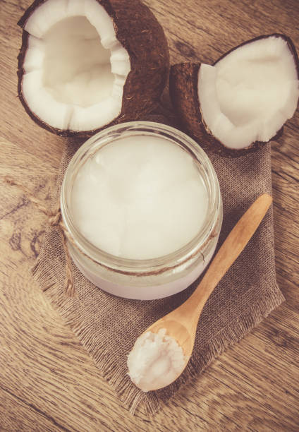 istock Coconut oil and fresh coconuts on a wooden table. 868103392