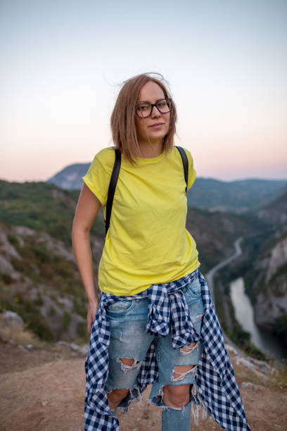 istock Pretty Young Woman looking off a cliff into valley 868106996