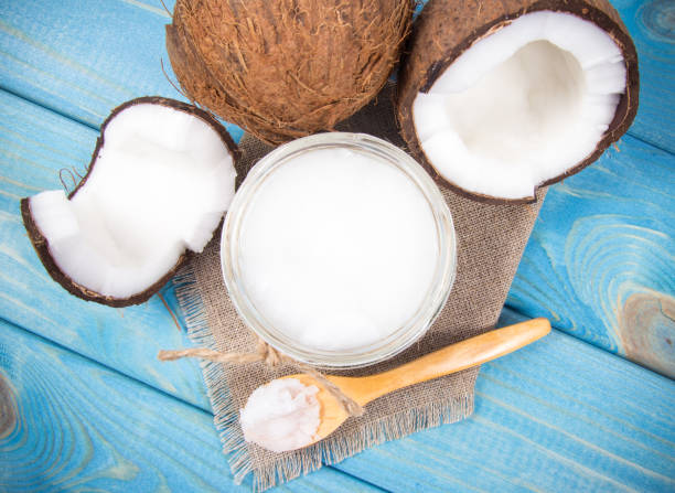 istock Coconut oil and fresh coconuts on a wooden table. 868109244