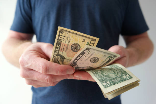 Man counting US dollar bills cash on hand
