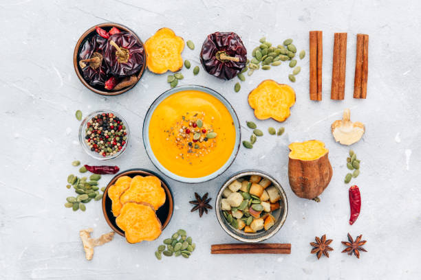 istock Pumpkin soup decorated seeds and thyme in white bowl on blue table top view. Flat lay styling. 868109508