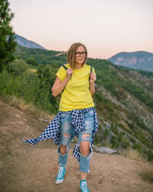 istock Pretty Young Woman looking off a cliff into valley 868110096
