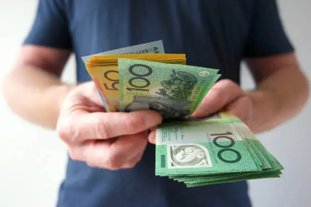 Photo of Man counting hundreds and fifties Australian dollar bills