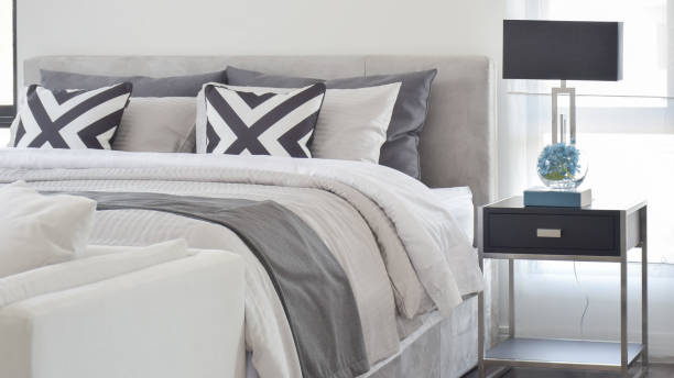 Modern Gray tone bedding and bedside table and lamp in black stock photo