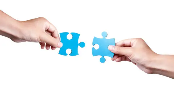 Photo of Two Puzzle Pieces Coming Together isolated on white background