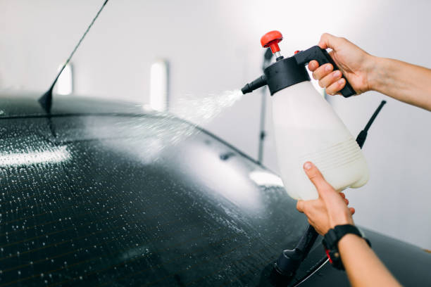 istock Male hand with spray, car window tint installation 868129620