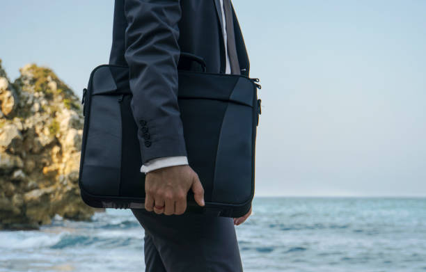Waiting businessman with handbag on the beach