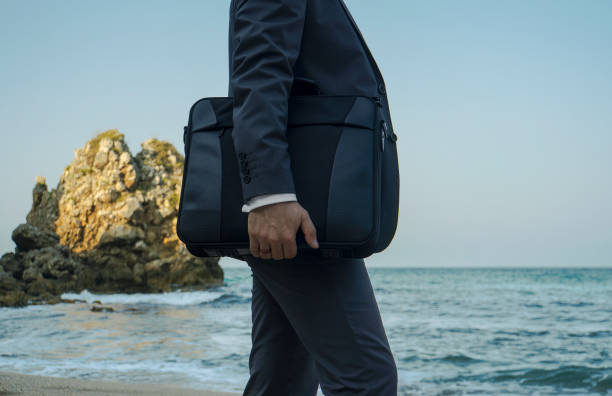 istock Walking businessman with handbag on the beach 868143242