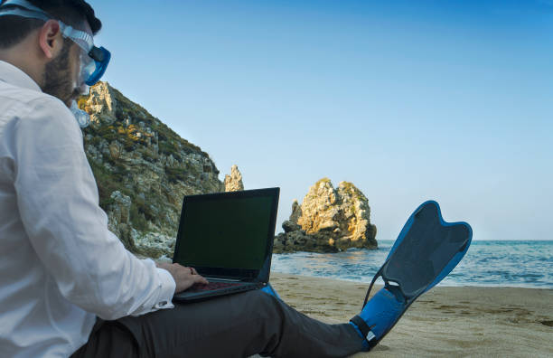 istock Businessman with snorkel use computer on the beach 868143626
