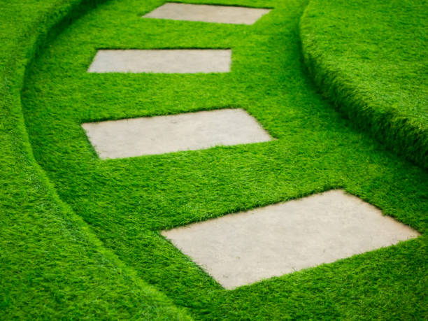 istock Artificial green grass walk way with concrete plate background 868155826