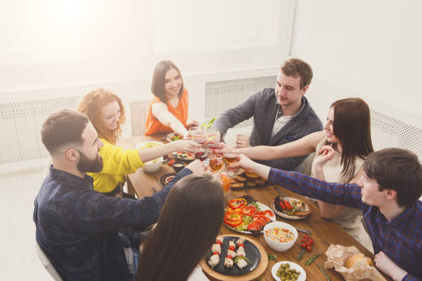 istock People say cheers clink glasses at festive table dinner party 868165632
