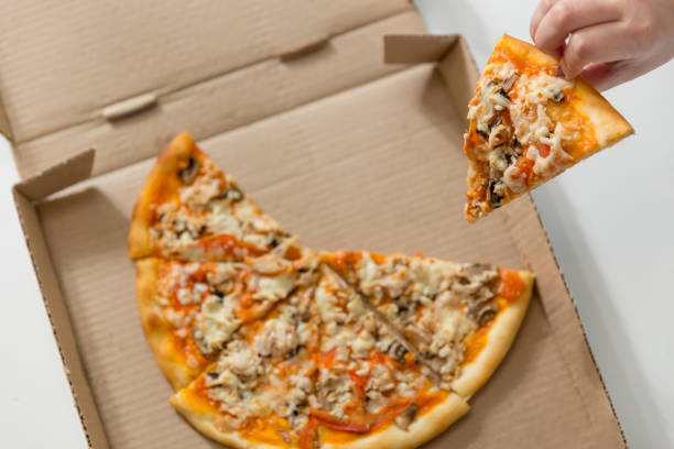 pyszna piękna pizza jest w pudełku. ręka bierze kawałek pizzy - carton horizontal portion part of zdjęcia i obrazy z banku zdjęć