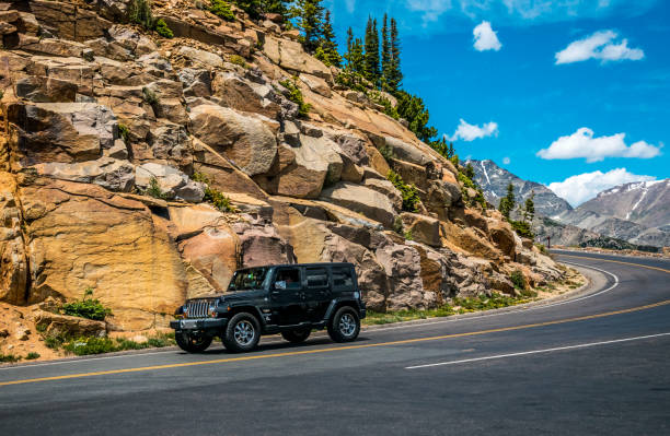 поездка в дебрях колорадо. автомобильный джип на горной дороге в скалистых горах - jeep wrangler стоковые фото и изображения