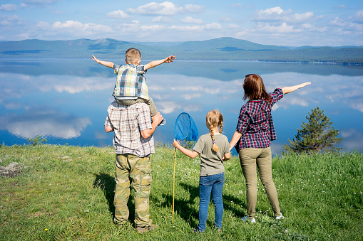 Happy family hiking together on a montain lake