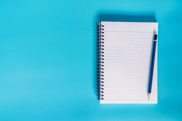 istock top view notebook paper on blue pastel color background with space. 868177106