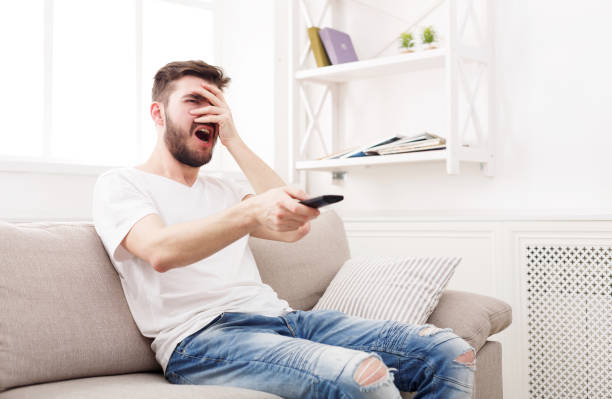 istock Thrilled young man watching tv at home 868180510