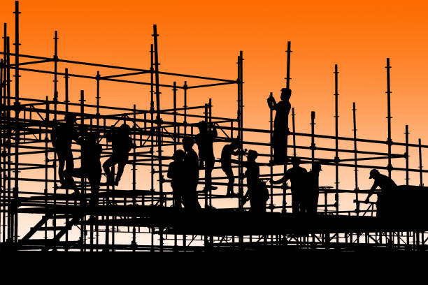 istock Silhouette of construction workers working on scaffolding with twilight sky 868181554