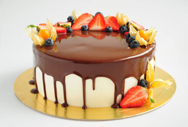 Cake in chocolate glaze with strawberries, blueberries and physalis.