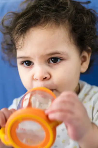 Stock photo of 18 month old baby girl drinking from her baby bottle.