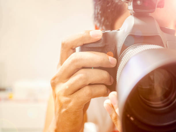 istock High key photo of photographer is using DSLR camera 868206696