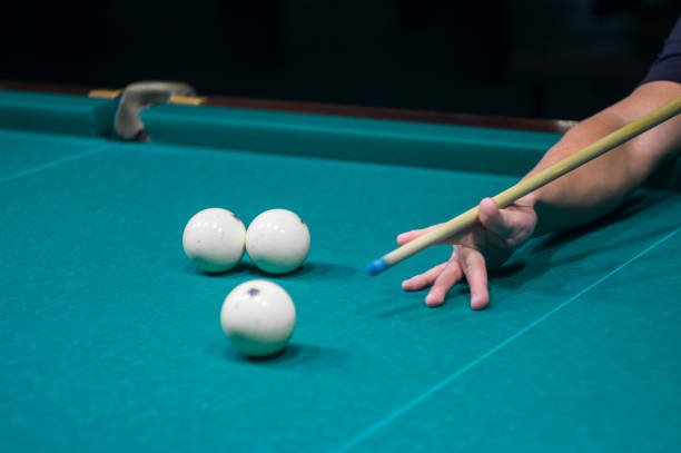 istock billiard green table in hall with white balls with man hand 868209104