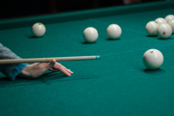 istock billiard green table in hall with white balls with man hand 868212572