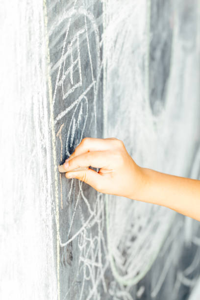istock Kid's Hand Writing with Chalk on  Blackboard 868213764