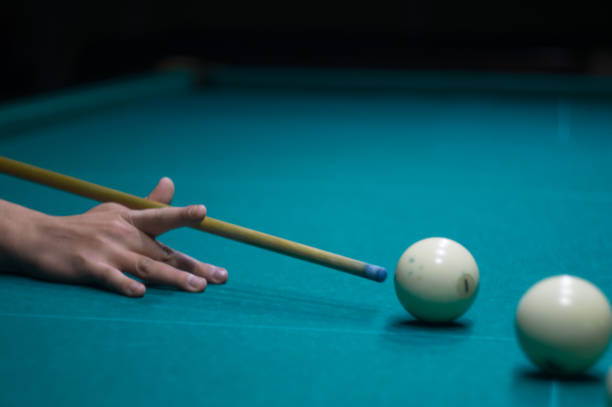 istock billiard green table in hall with white balls with man hand 868216760