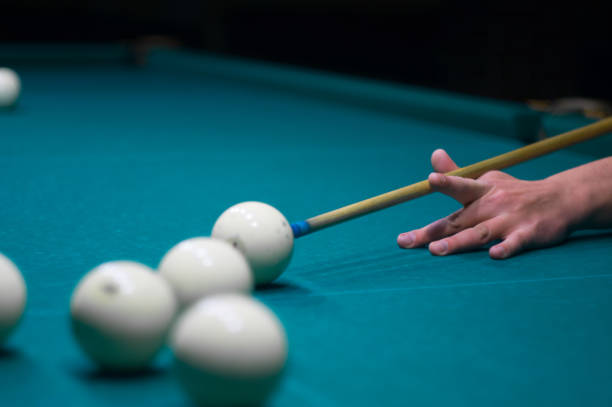 istock billiard green table in hall with white balls with man hand 868216844