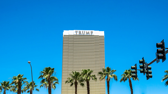 Las Vegas, Nevada, USA - June 18, 2017: Hotel Trump Las Vegas, landmark of the Strip Street, the main street of Las Vegas. Skyscraper and hotel Donald Trump against the blue sky and palm trees. The modern infrastructure of Las Vegas