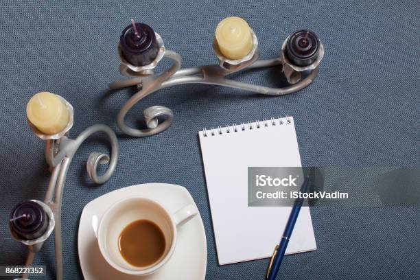 Forged Metal Candlestick With Candles A Cup With Unapproved Coffee There Is An Open Notepad And A Pen Fallen Autumn Leaves Of Yellow And Red Are Scattered On The Surface Stock Photo - Download Image Now