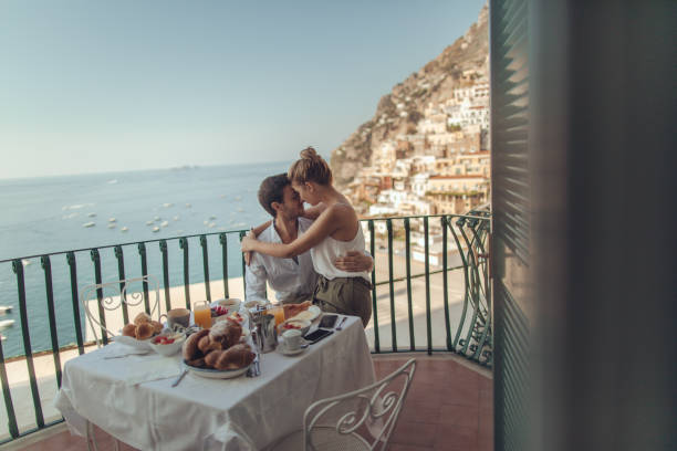 Honeymooners in Italy Photo of a beautiful loving couple having breakfast on the terrace with a view of amazing Positano, Italy amalfi food stock pictures, royalty-free photos & images
