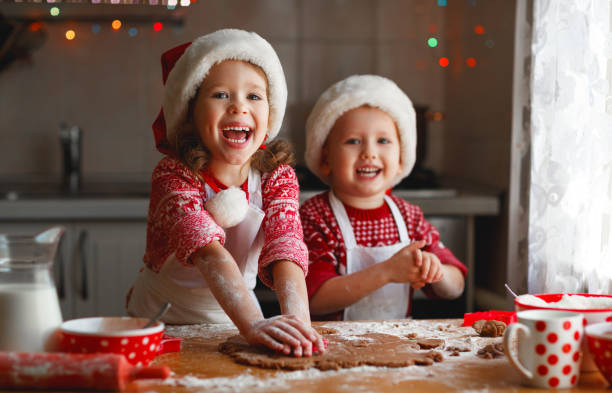 niños felices hornear galletas de navidad - christmas child cookie table fotografías e imágenes de stock