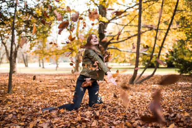 istock Woman throwing leaves in the forest 868231022