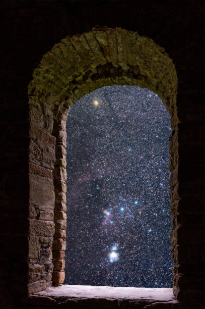 istock The Orion constellation visible through an old ancient stone window. 868231100