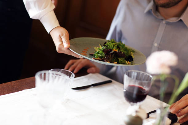 istock Romantic couple dating in restaurant being served by waiter 868235018
