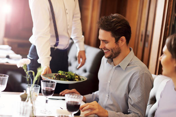 istock Romantic couple dating in restaurant being served by waiter 868235196