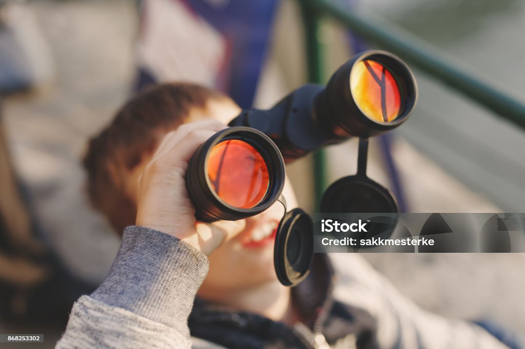 Little boy watching airplane on sky by binoculars Little caucasian boy watching airplane on sky by binoculars, depth of field Airshow Stock Photo
