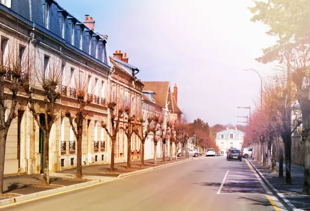 Romantic cityscape of Chantilly with old houses on both sides of road at sunny day, Oise, France