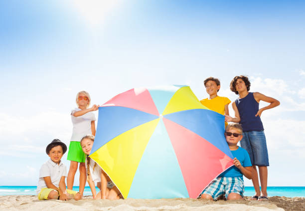 istock Many kids in large group behind beach umbrella 868264636