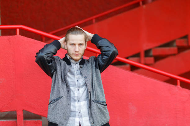 istock Handsome young man posing on the camera on a red background. 868267376