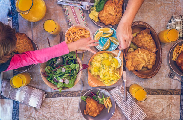 comendo o wiener schnitzel com batatas e salada verde - cutlet schnitzel pork scaloppini - fotografias e filmes do acervo