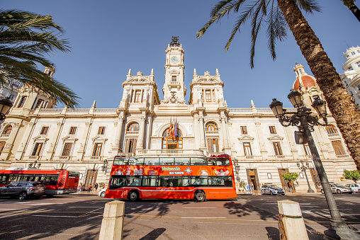 VALENCIA, SPAIN - August 19, 2017: View on the city hall building with tourist bus during the morning light in Valencia city in Spain